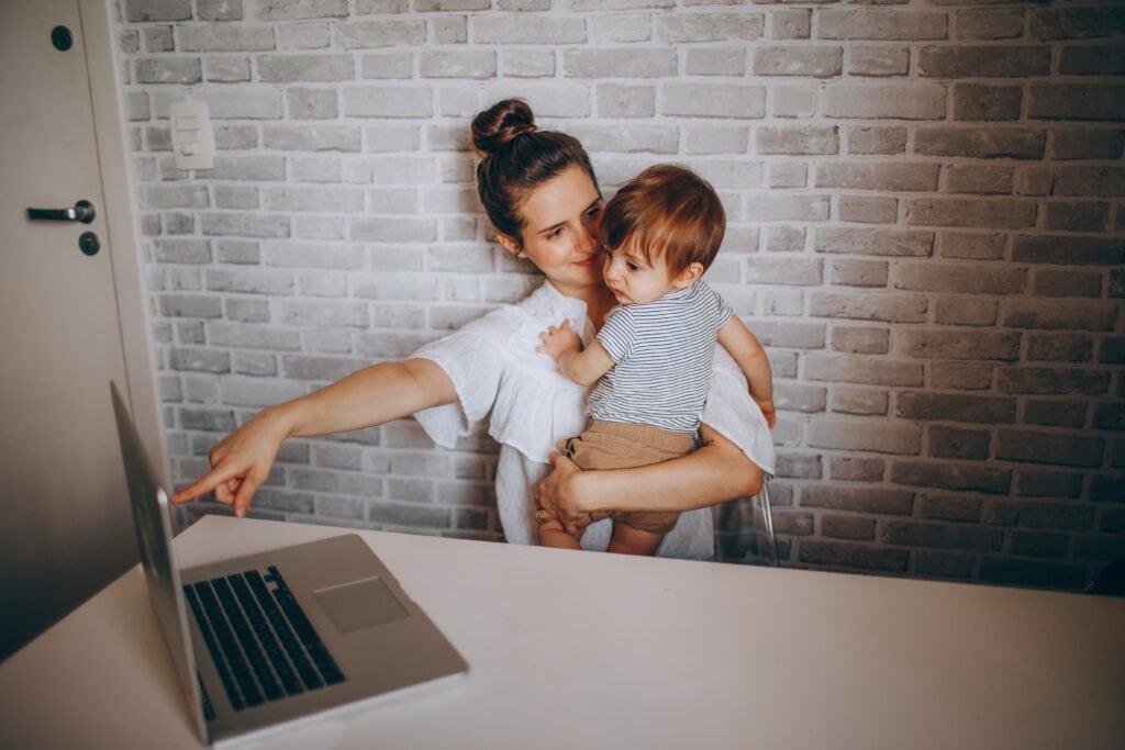 Mompreneur business owner working with baby and laptop